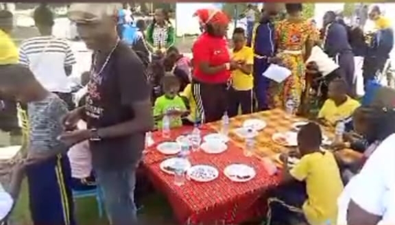 Children and volunteers sharing a meal at a G4G community gathering